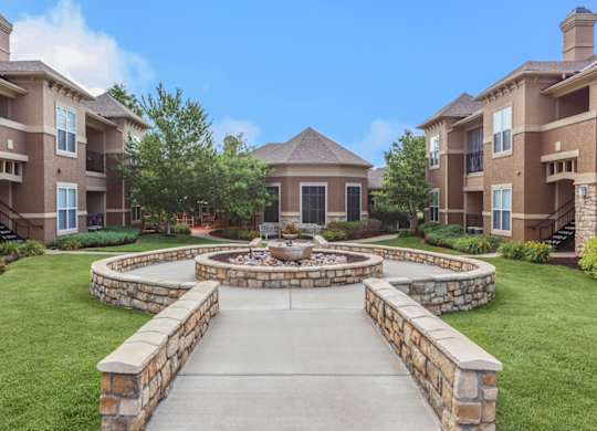 A stone courtyard with a fountain in the center of residential buildings.
