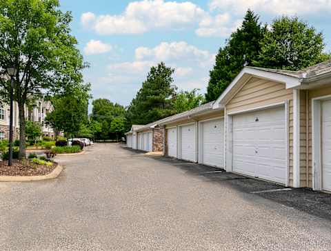 A row of white garage doors are on the right side of a street. at Villas at Cordova, Cordova, 38018