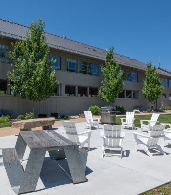a patio with chairs and tables in front of a building at Ames Shovel Works Apartments in North Easton