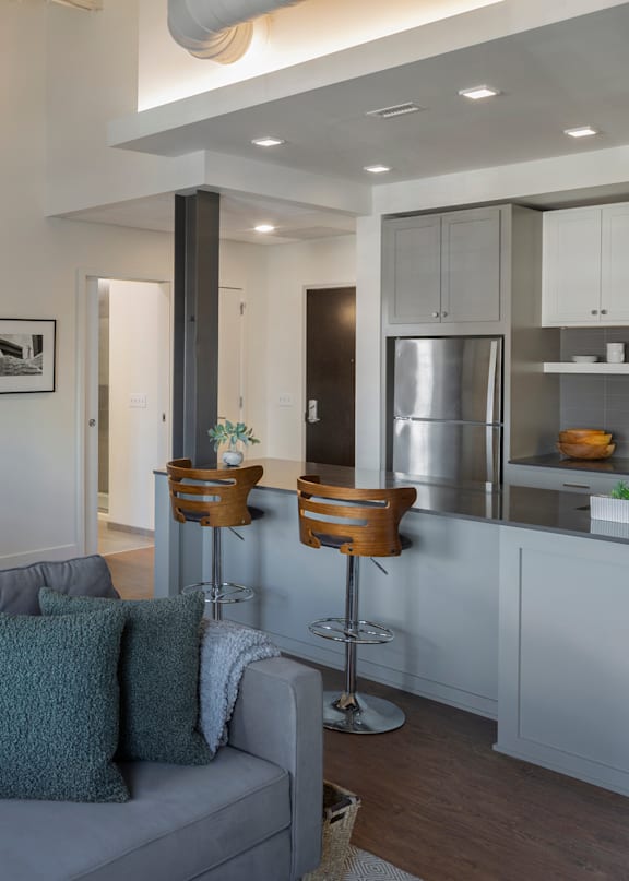 A large metal structure in the foreground of a courtyard with a brick building in the background.