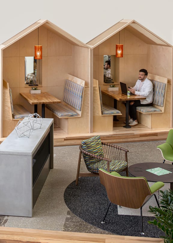 A living room with a green couch and red lampshades.