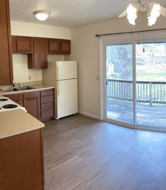 A kitchen with a white fridge and wooden cabinets.