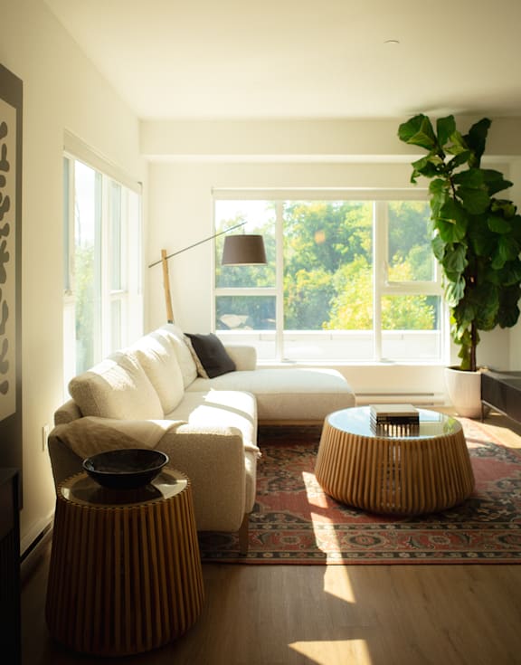 A living room with a white couch and a large window.