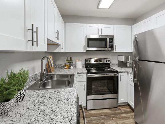 Model Kitchen with White Cabinets and Wood-Style Flooring at Ridgeline Apartments in Tucson, AZ-LRGAM.