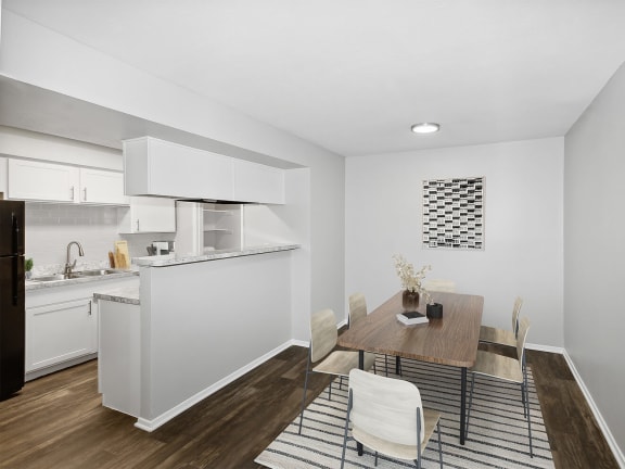 Model Dining Room with Wood-Style Flooring and View of Kitchen at Summit Ridge Apartments located in Arlington, TX-LRGAM.