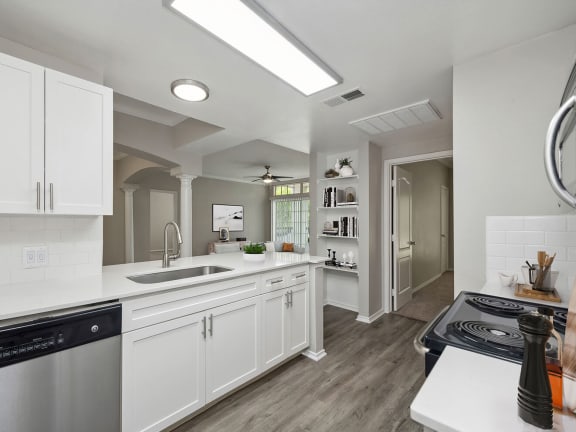 Model Kitchen with Wood-Style Flooring and White Cabinets at Allure North Dallas Apartments located in Dallas, TX-LRGAM.