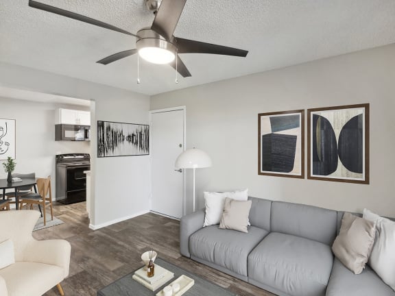 Model Living Room with Wood-Style Flooring and View of Dining/Kitchen Area at Solano Springs Apartments located in Tucson, AZ-LRGAM.