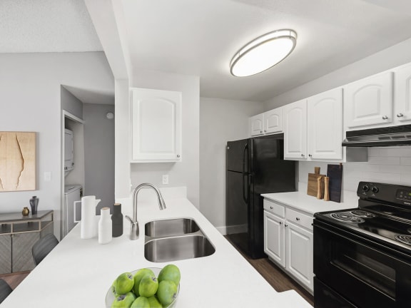 Model Kitchen with White Cabinets and Wood-Style Flooring at Vue at Baymeadows Apartments in Jacksonville, FL-LRGAM.