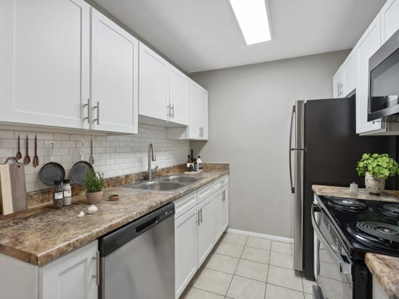 Model Kitchen with White Cabinets and Tile Flooring at Liberty Creek Apartments in Aurora, CO-LRGAM.