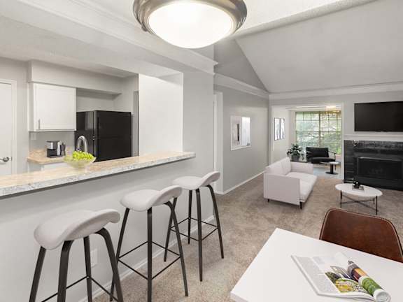 Model Kitchen with View of Living Room at Cobblestone Apartments located in Arlington, TX-LRGAM.