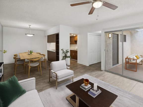 Model Living Room with Wood-Style Flooring, View of Kitchen and Patio Accessibility at Lakeside Casitas Apartments located in Tucson, AZ-LRGAM.