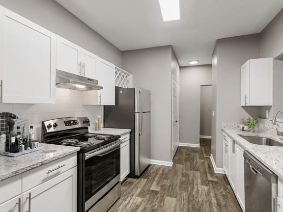 Model Kitchen with White Cabinets and Wood-Style Flooring at Parkside at Town Center Apartments in Marietta, GA-LRGAM.