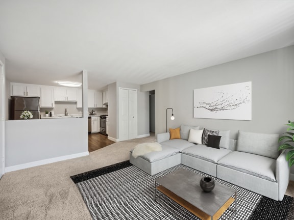 Model Living Room with Carpet and View of Kitchen at Middlesex Crossing Apartments located in Billerica, MA-LRGAM.