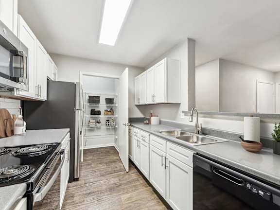 Model Kitchen with White Cabinets and Wood-Style Flooring at Lake Cameron Apartments located in Apex, NC-LRGAM.