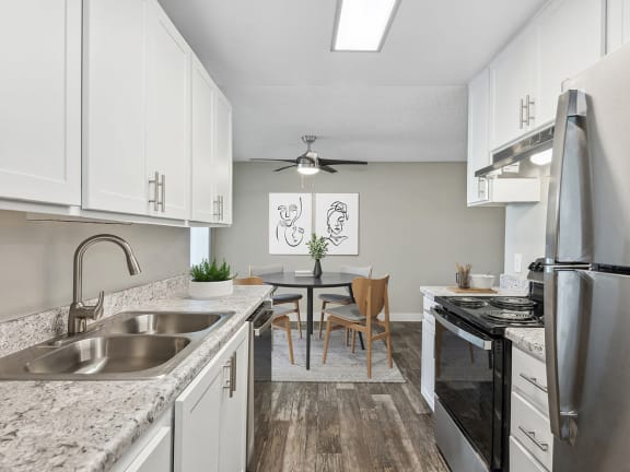 Model Kitchen with White Cabinets and Wood-Style Flooring at Peaks on 4th Apartments located in Avondale, AZ-LRGAM.