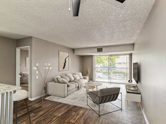 Model Living Room with Wood-Style Flooring and Patio Accessibility at Crystal View Apartments located in Garden Grove, CA.