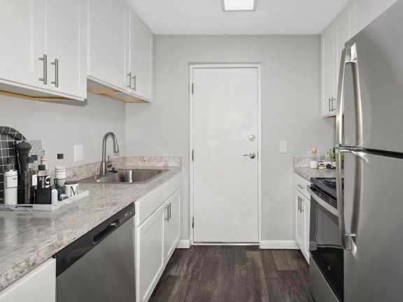 Model Kitchen with White Cabinets and Wood-Style Flooring at Stone Ends Apartments in Stoughton, MA-LRGAM.