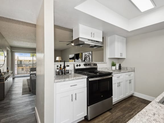 Model Kitchen with White Cabinets and Wood-Style Flooring at Villages at Metro Center located in Phoenix, AZ-LRGAM.