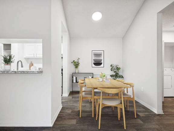 Model Dining Room and Kitchen with Wood-Style Flooring at Rosehill Preserve Apartments located in Orlando, FL-LRGAM.