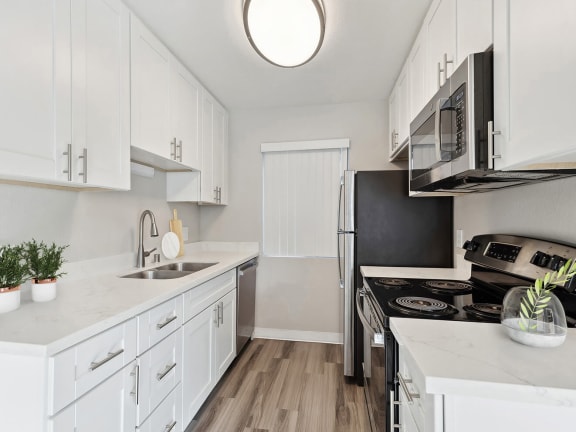 Model Kitchen with White Cabinets and Wood-Style Flooring at Bridges on Sunset Apartments in Suisun City, CA-LRGAM.