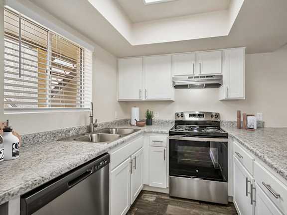 Model Kitchen with White Cabinets and Wood-Style Flooring at Butler Ridge Apartments located in Glendale, AZ-LRGAM.