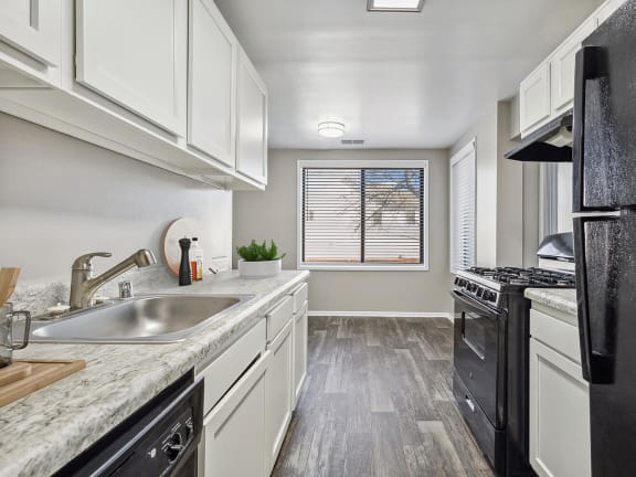 Model Kitchen with White Cabinets and Wood-Style Flooring at Spring Parc Apartments in Silver Spring, MD-LRGAM.