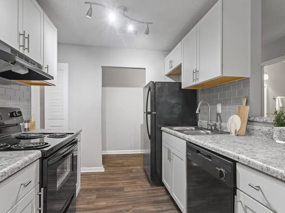 Model Kitchen with White Cabinets and Wood-Style Flooring at Corners at 1700 Apartments in Atlanta, GA-LRGAM.