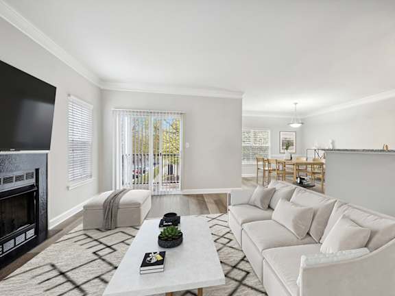 Model Living Room with Wood-Style Flooring, Fireplace and Patio Accessibility at Dulles Green Apartments located in Herndon, VA-LRGAM