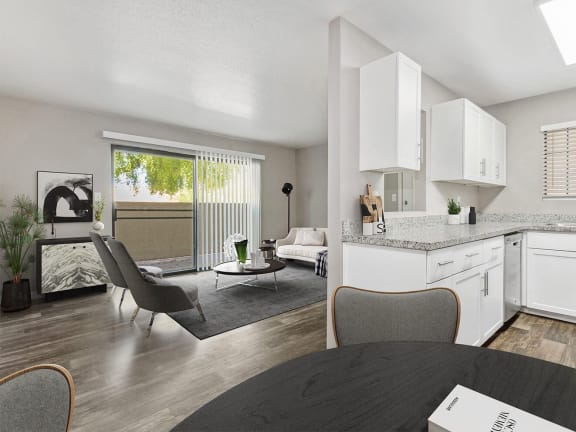 Model Kitchen with White Cabinets, Wood-Style Flooring and View of Living Room at Lore at South Mountain Apartments located in Ahwatukee, AZ-LRGAM.