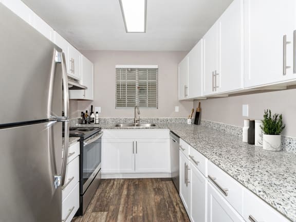 Model Kitchen with White Cabinets and Wood-Style Flooring at Array at South Mountain Apartments in Ahwatukee, AZ-LRGAM.