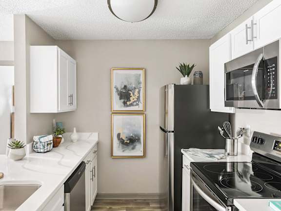 Model Kitchen with White Cabinets and Wood-Style Flooring at Mirage on Kernan Apartments located in Jacksonville, FL-LRGAM.