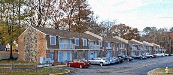 a row of houses with cars parked in front of them