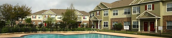 A swimming pool in front of apartment buildings.