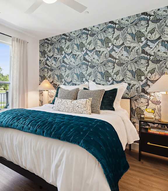A bedroom with a large bed and a green blanket.