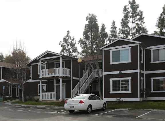 a row of houses with a car parked in a parking lot