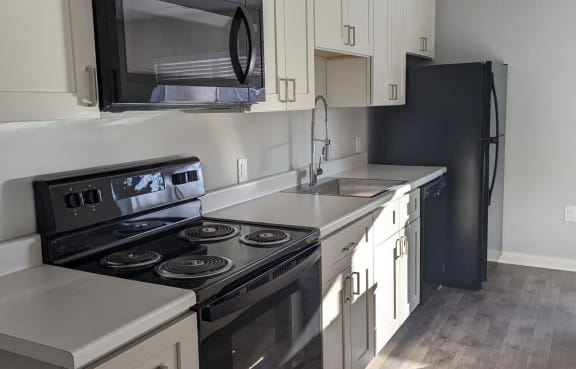 a kitchen with black appliances and white cabinets