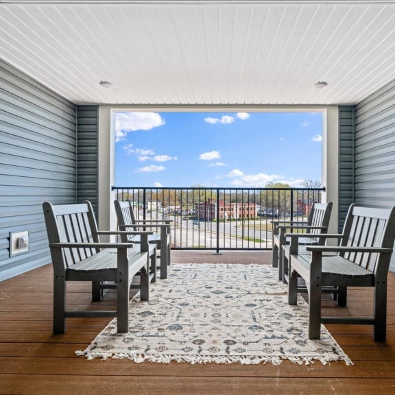 a dining room with a table and chairs in front of a balcony