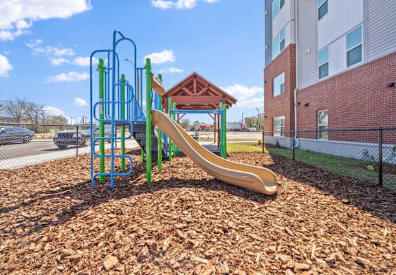 a playground with a slide at an apartment complex