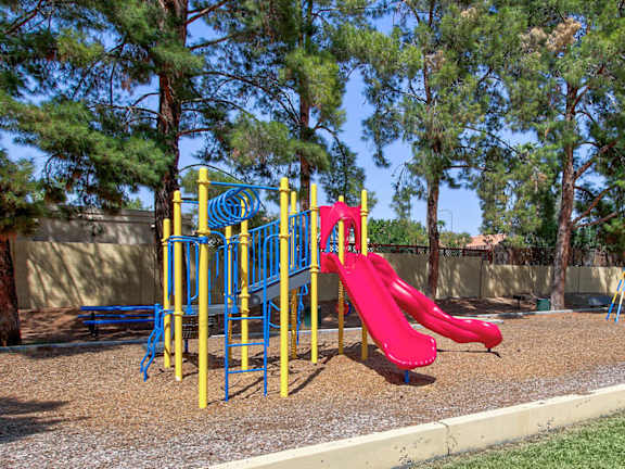 A playground with a red slide and yellow climbing structure at Glen at Mesa, Arizona, 85201