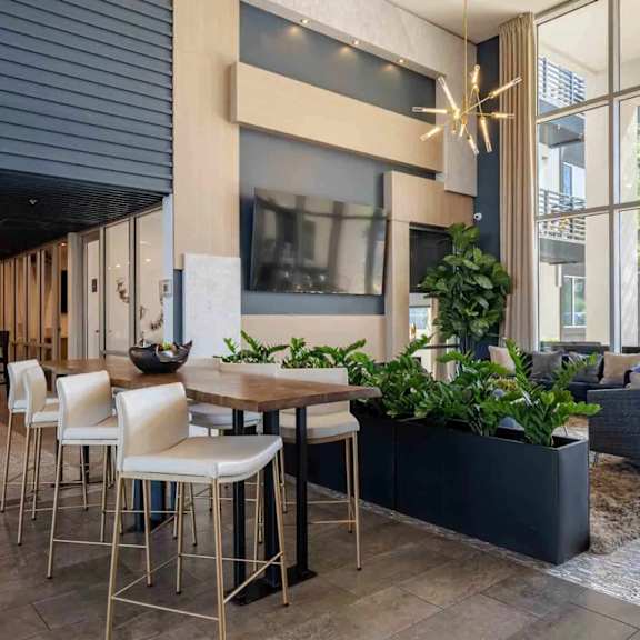 A modern dining area with a wooden table and white chairs.
