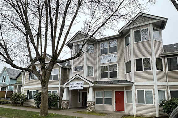 Apartment building with a sign that says "Now Leasing".