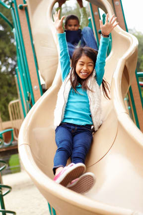 a young girl going down a slide on a playground slide