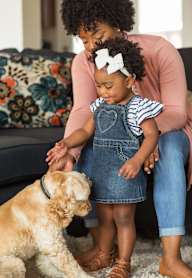 A woman and a child are petting a dog.