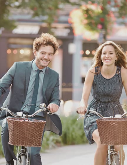 A man and a woman are riding bicycles together.