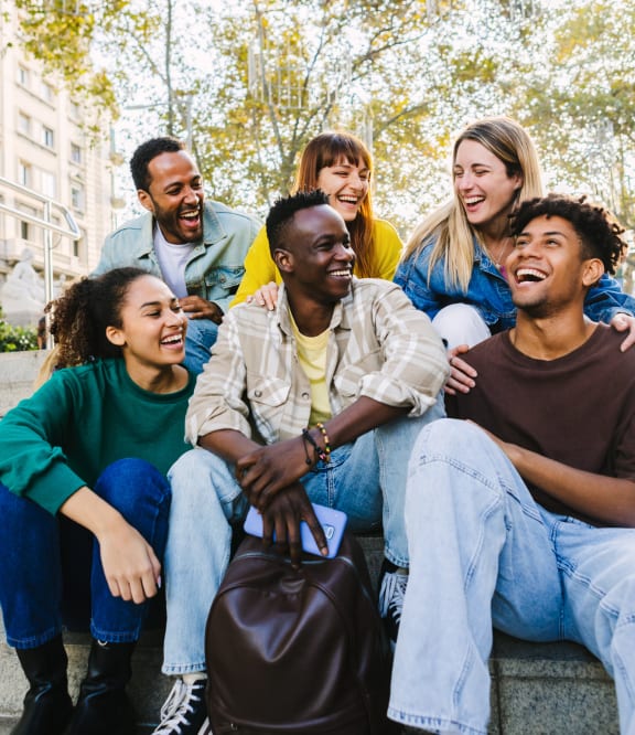 group of young people sitting on a bench in the park stock photo #