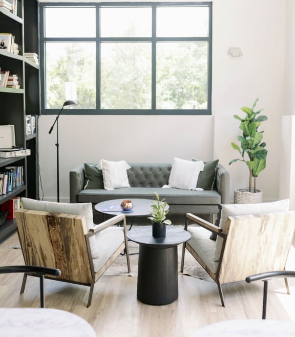 Library lounge with a couch and chairs at The Merchant Apartments, South Carolina 29403