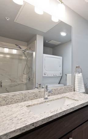 A bathroom with a marble countertop and shower at ONE18 West Street Residential Apartments, Reno, NV 89501