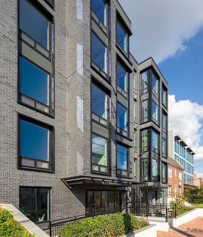 A modern building with a black facade and large windows.