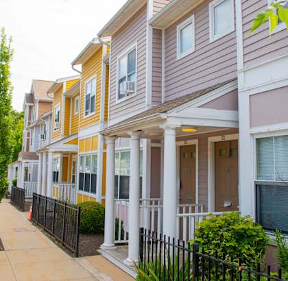 a row of townhomes with a sidewalk in front of them