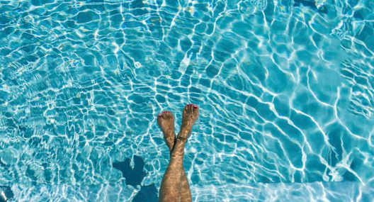A woman in a hat is floating in a pool.